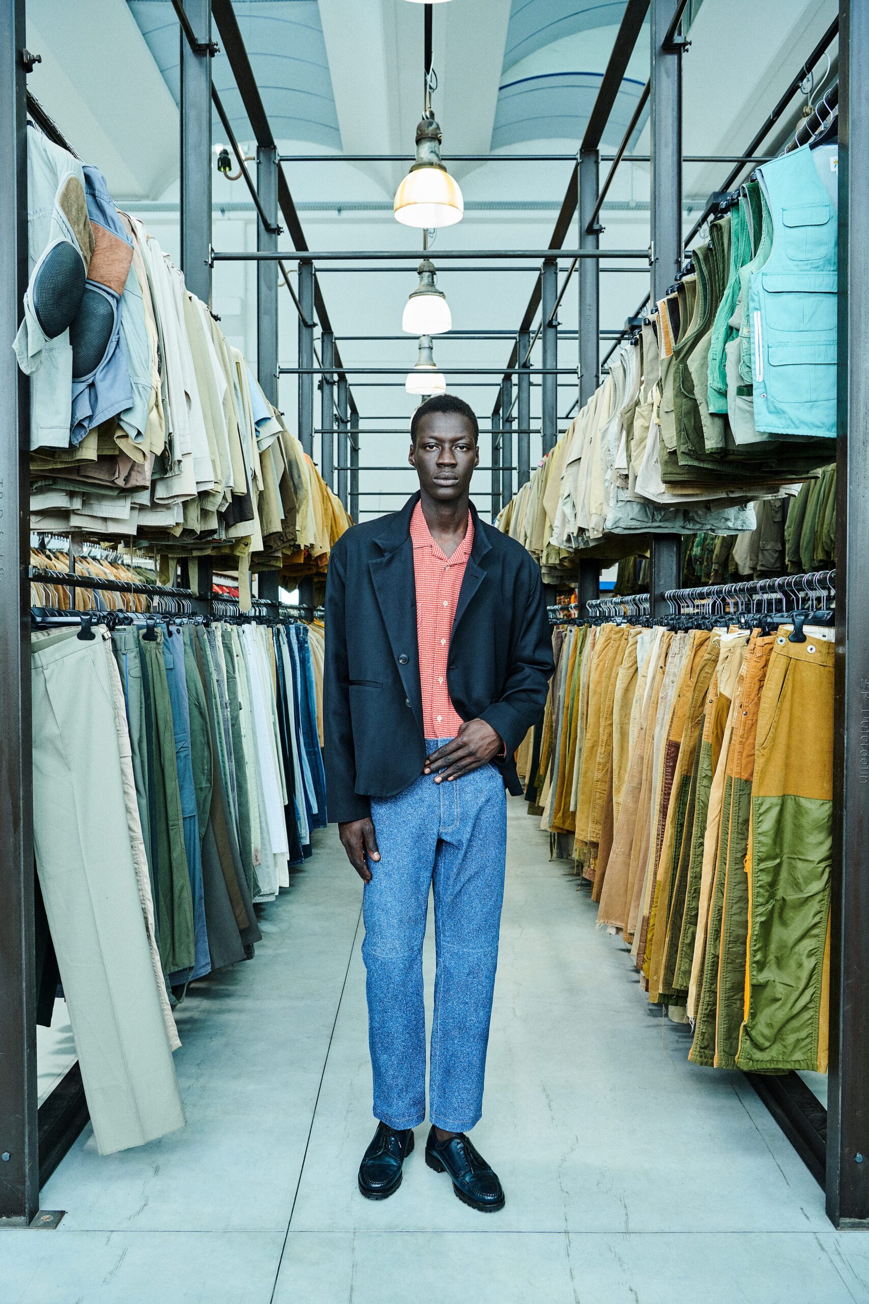 A relaxed black jacket paired with blue cotton straight-leg pants.