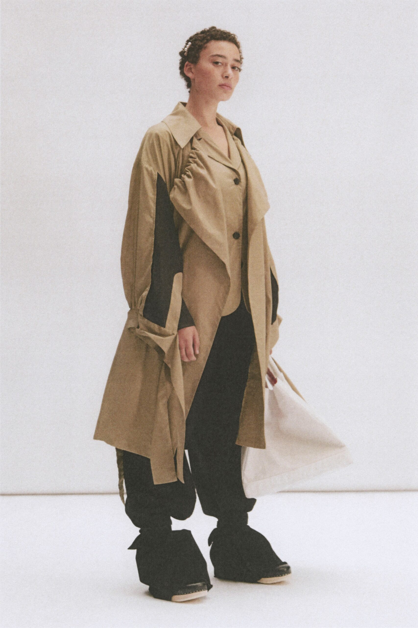 beige trench coat and black pants