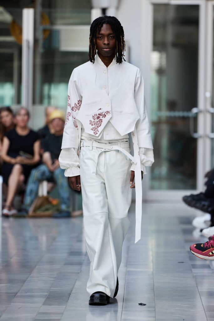 A white long-sleeve shirt with embroidery paired with matching white pants for a contemporary look.
