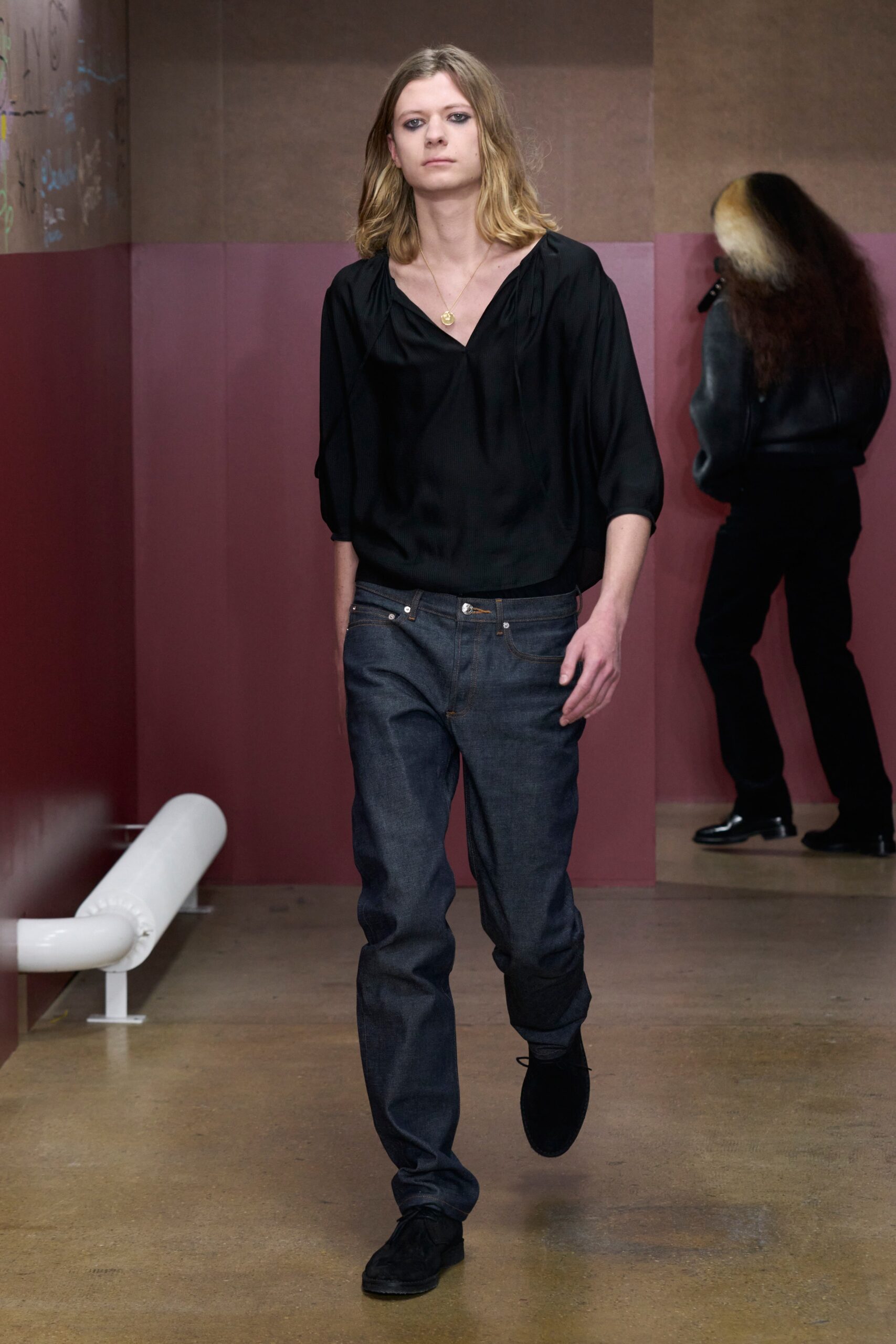 A relaxed black long-sleeve shirt paired with straight-leg blue denim jeans.