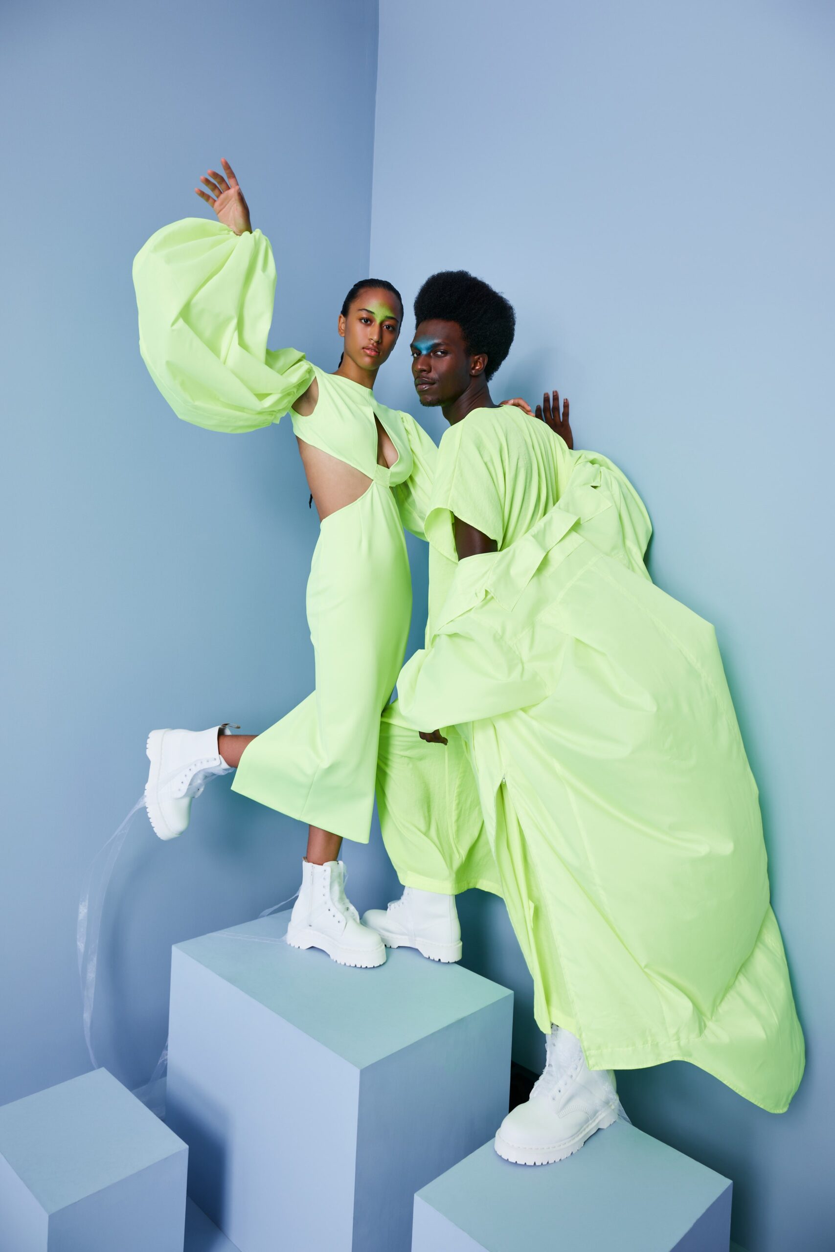 This fitted sleeveless dress in a vibrant green showcases a striking asymmetric design with cutout details that enhance its modern silhouette. The bold color and unique structure create a dynamic visual impact, making it a standout piece in any collection.