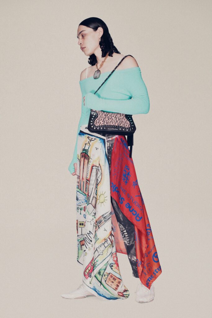 A relaxed blue off-shoulder top paired with colorful printed pants for a unique fashion statement.