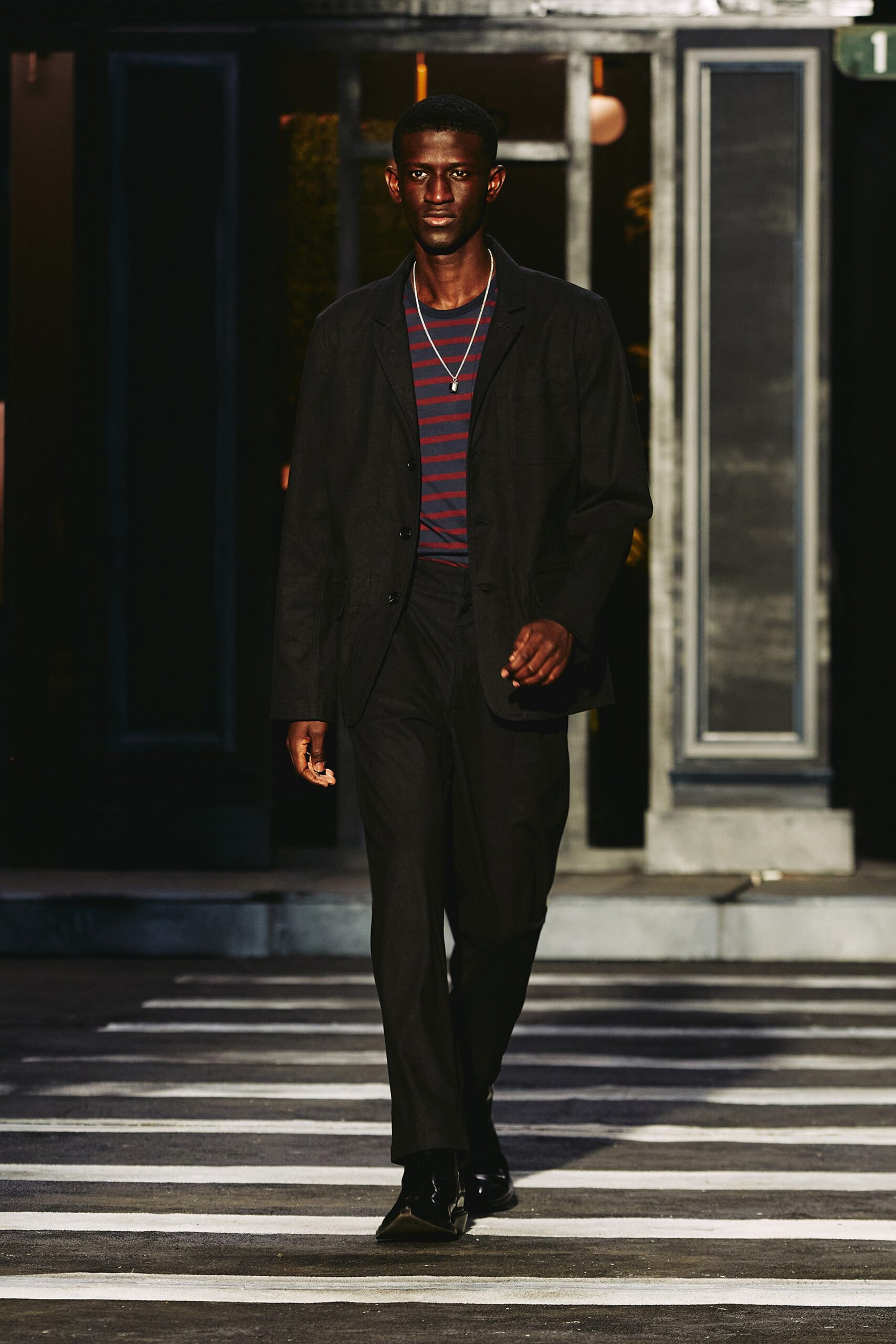 A tailored black suit with a collared shirt and straight-leg trousers.