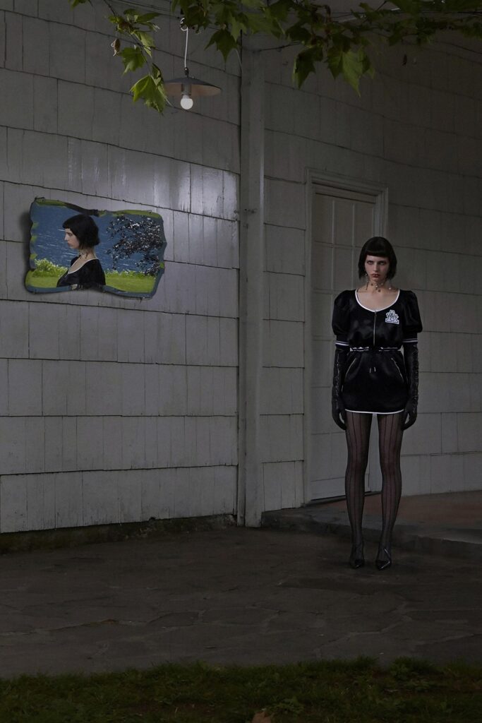A fitted black cotton dress with short sleeves and a pencil silhouette.