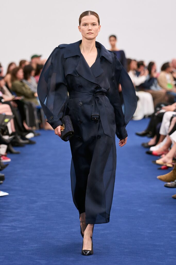 A relaxed navy silk coat dress with long sleeves and an asymmetric design, featuring a belted waist.