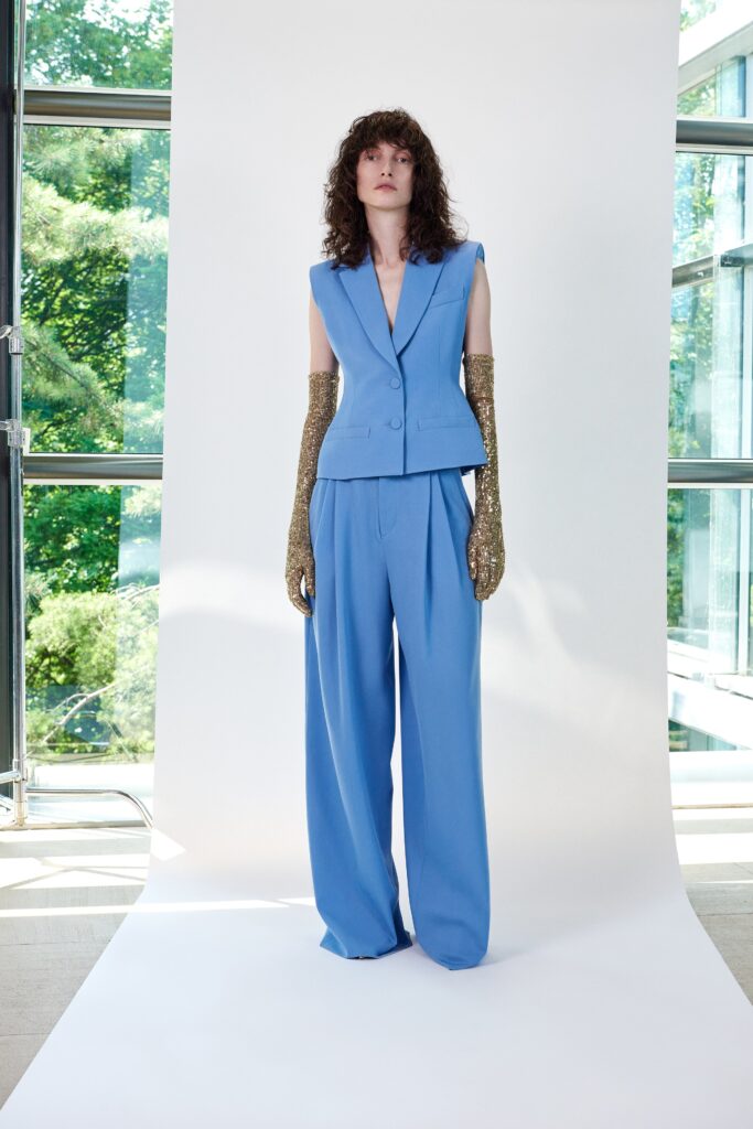 A relaxed blue cotton sleeveless blazer paired with wide-leg pants for a chic look.