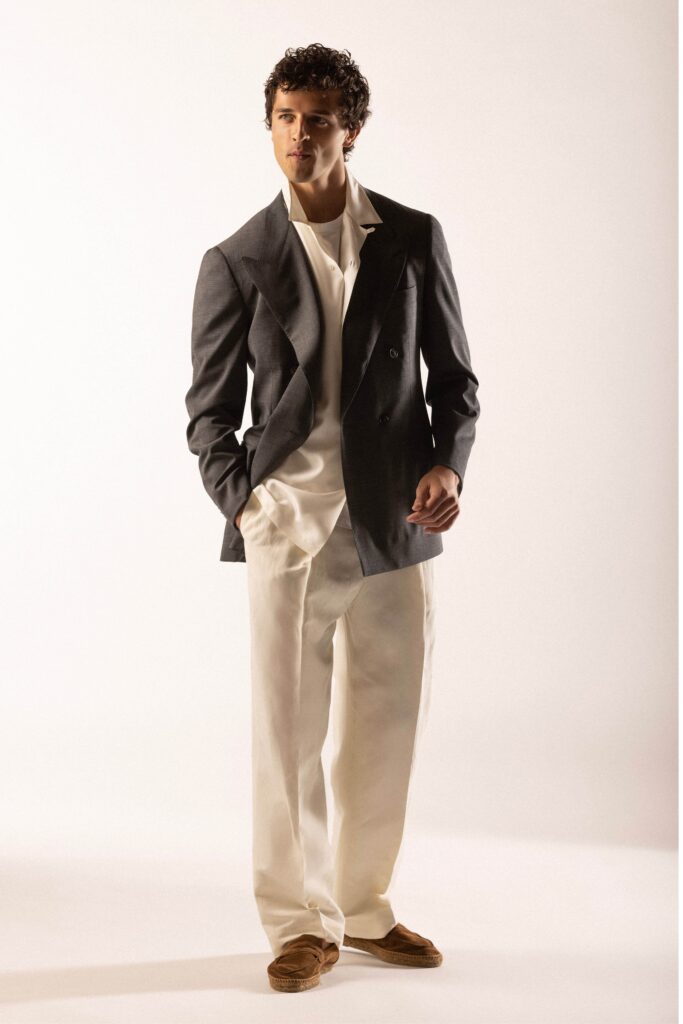 A relaxed gray blazer paired with white pants featuring a collared shirt and buttoned details.