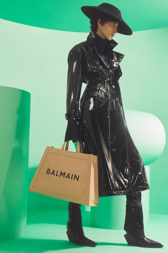 A fitted black leather coat with long sleeves and a belted design.