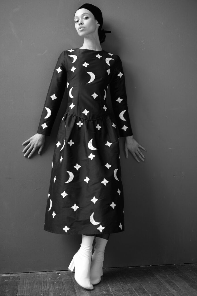 A relaxed black and white printed dress with long sleeves and a round neckline.