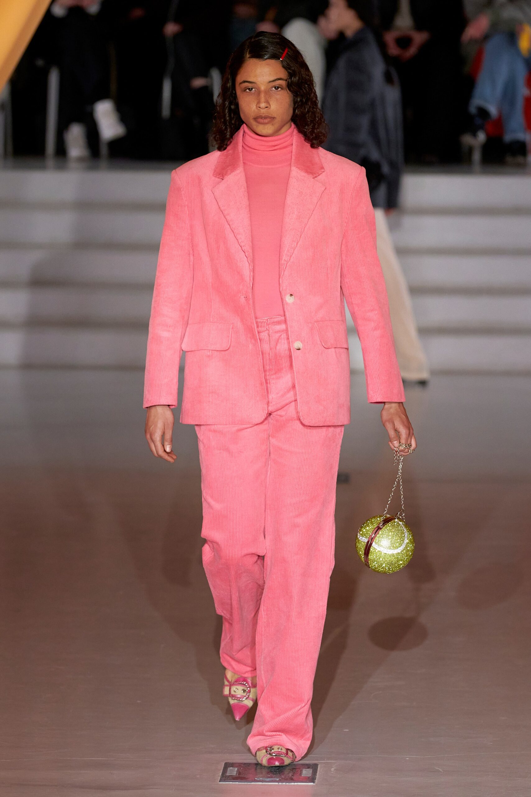 A fitted pink cotton suit with a collared long-sleeve top and straight-leg pants.