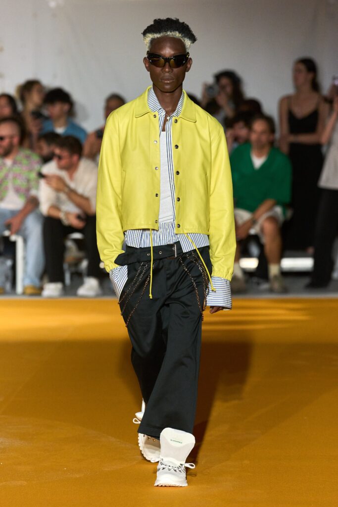 A relaxed yellow cotton jacket with a collared neckline, paired with black pants featuring a striped detail.