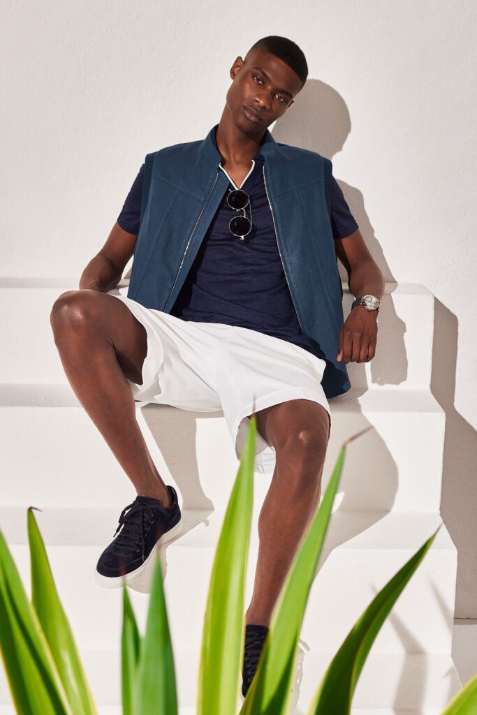 A relaxed blue cotton sleeveless vest paired with white shorts for a casual look.