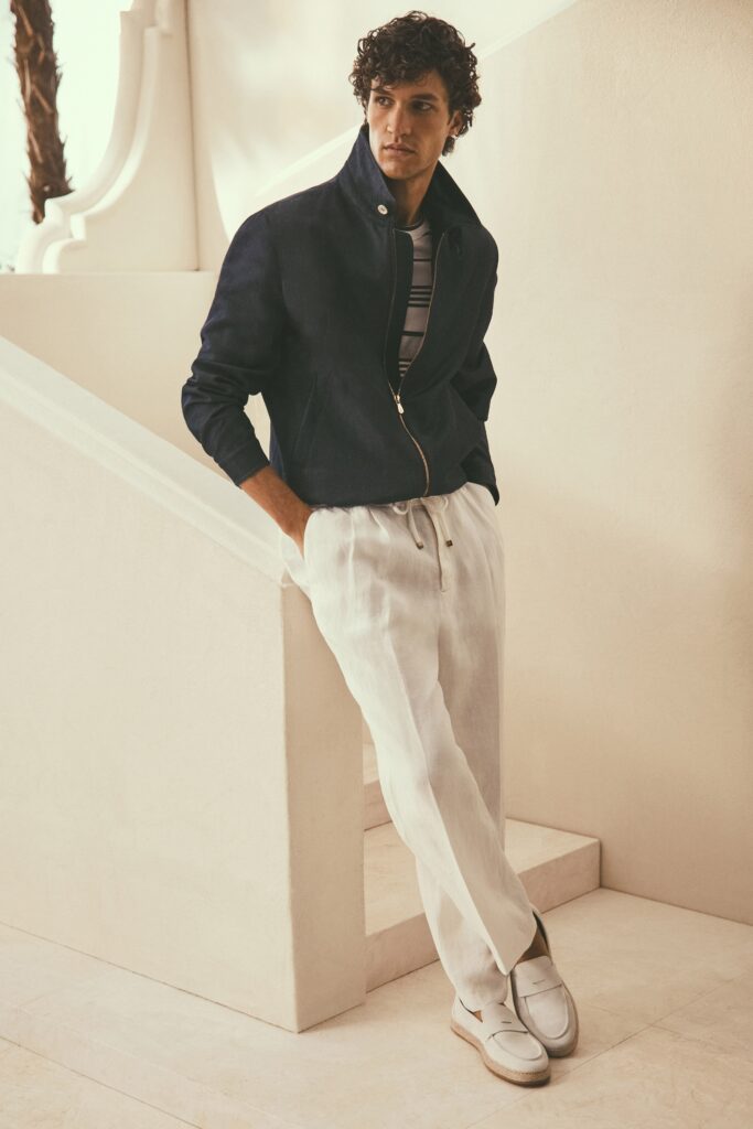 A relaxed navy cotton jacket paired with straight-leg white linen pants.