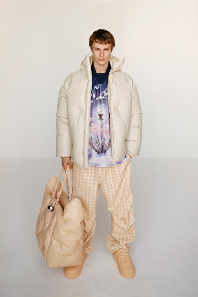 A relaxed-fit beige hooded jacket paired with printed blue top and checkered pants.