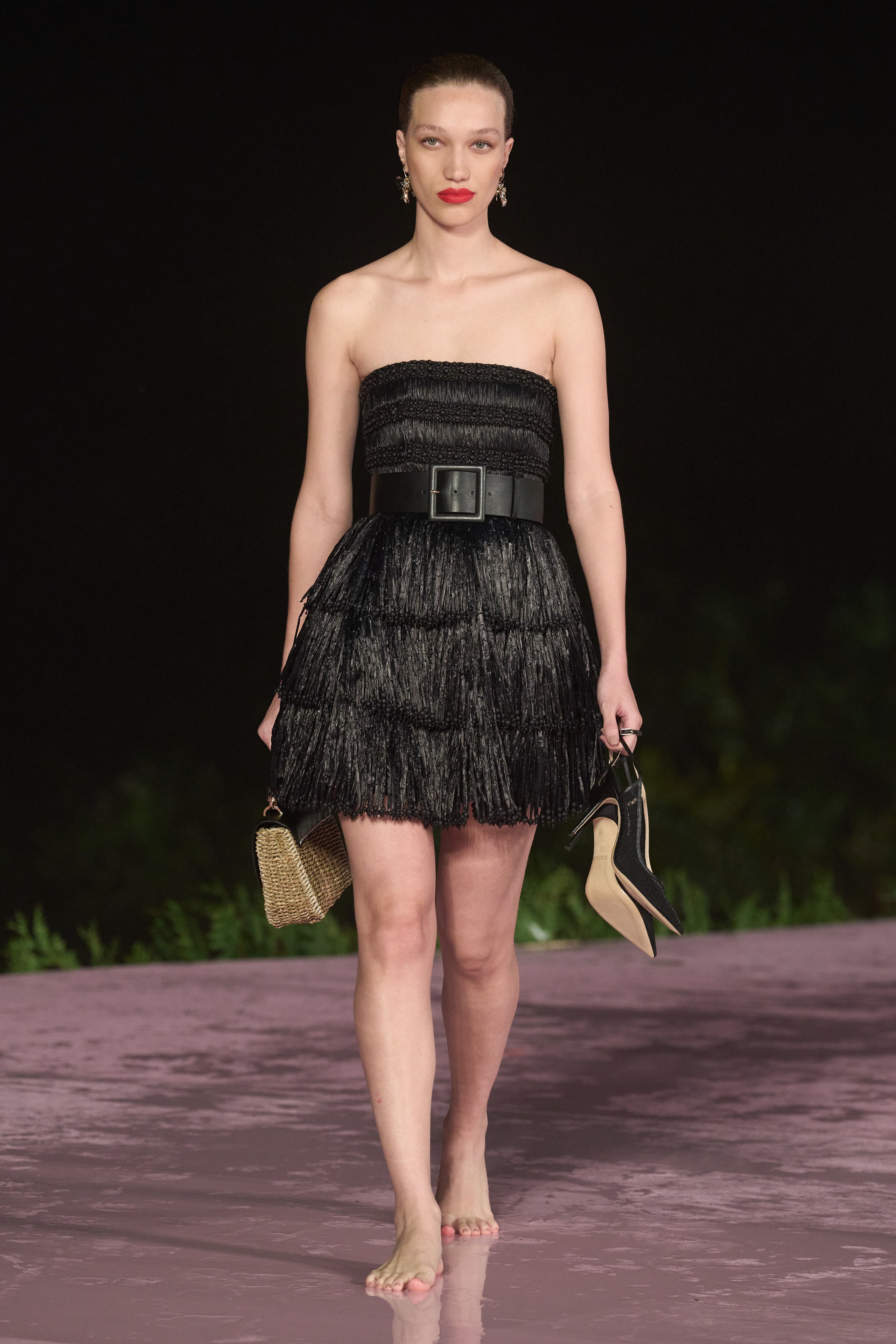A fitted black silk strapless dress featuring a fringed design for a unique silhouette.