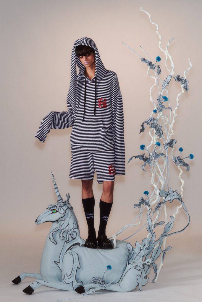 A relaxed black and white striped hoodie with long sleeves paired with matching shorts.