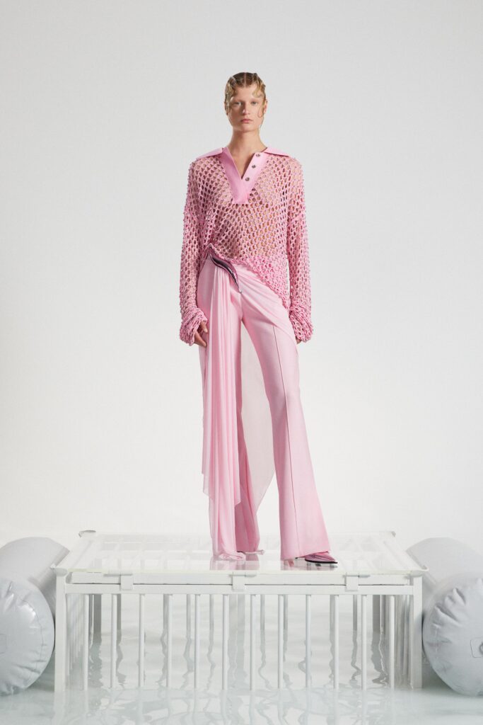 A relaxed pink long-sleeve top with a collared design paired with layered pants.