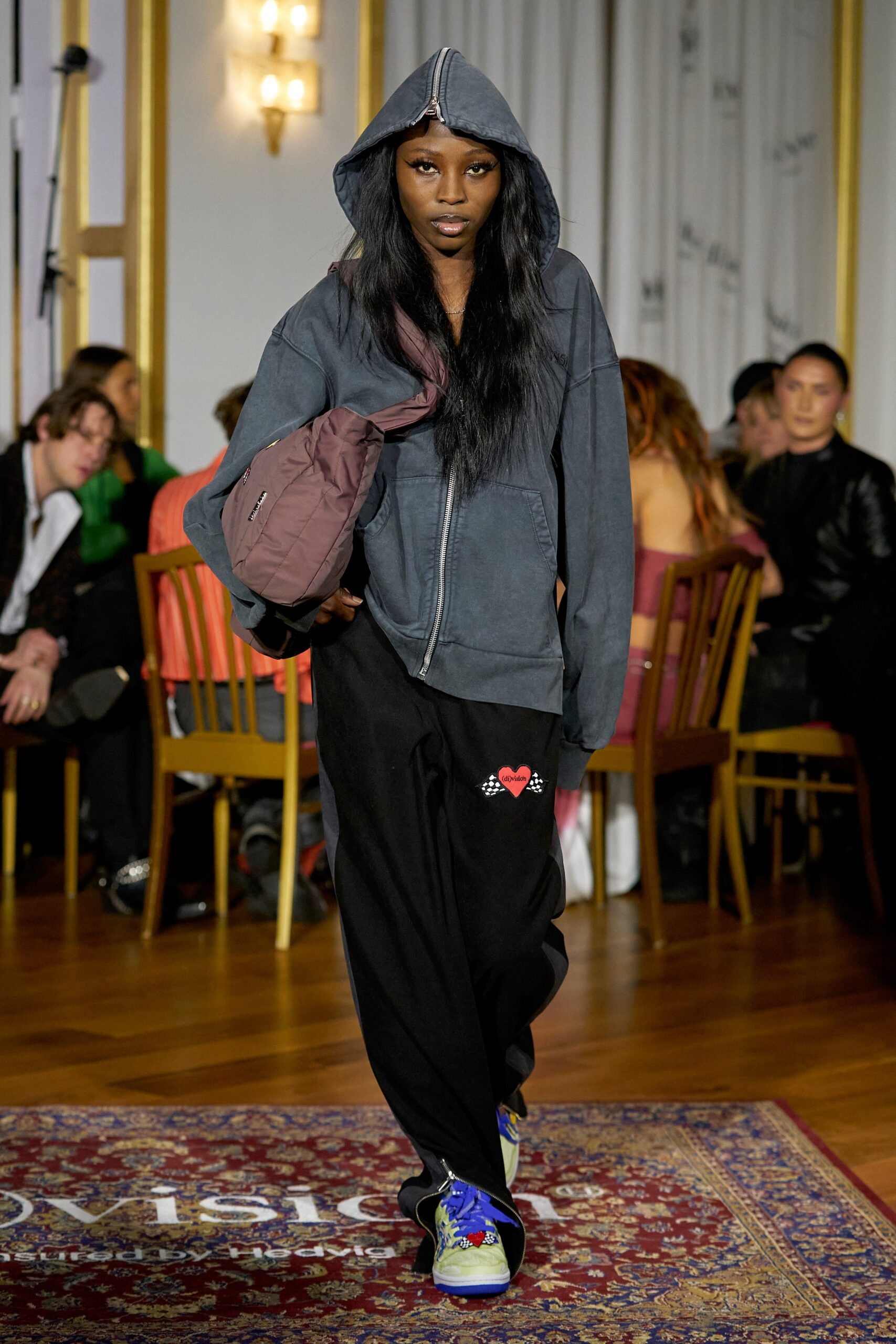 A relaxed gray hoodie with long sleeves paired with black printed pants.