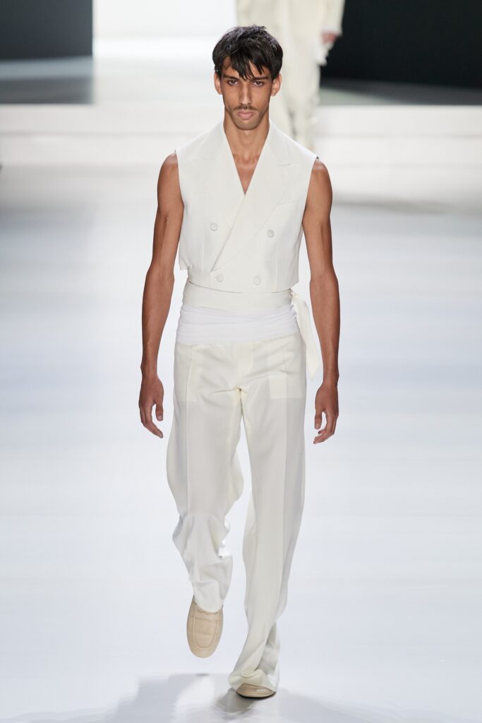 A fitted white sleeveless vest paired with wide-leg pants, featuring a collared design.