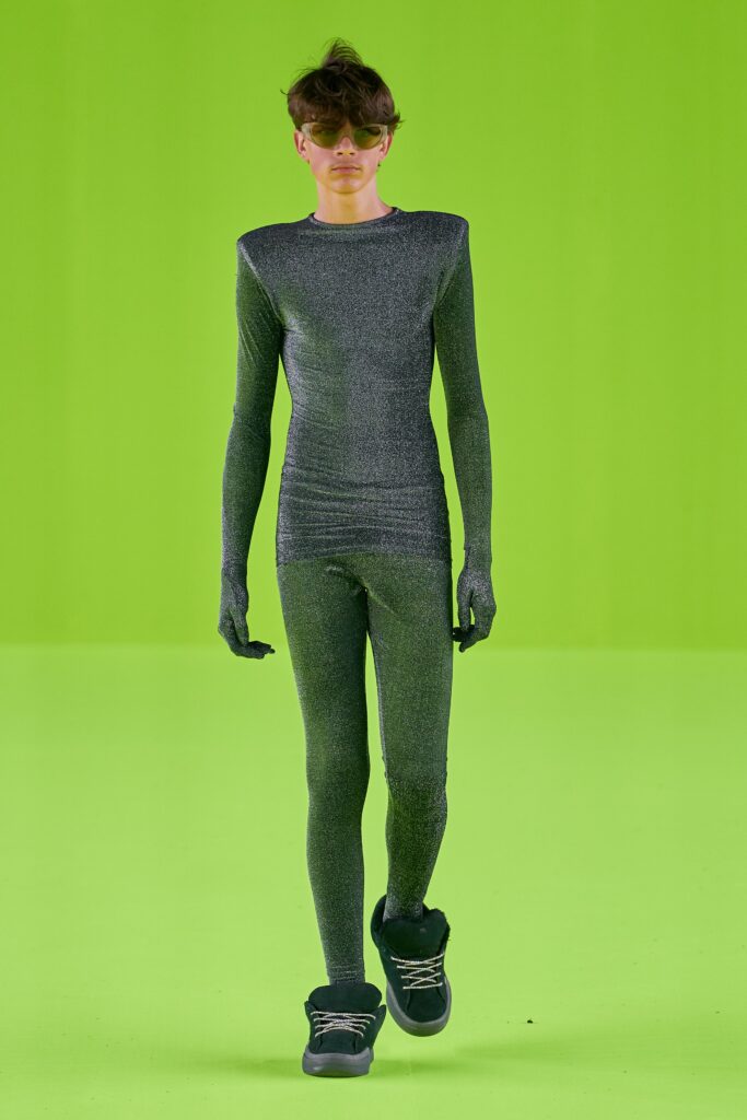 A fitted gray metallic catsuit with long sleeves and a high neckline, showcasing a sleek silhouette.