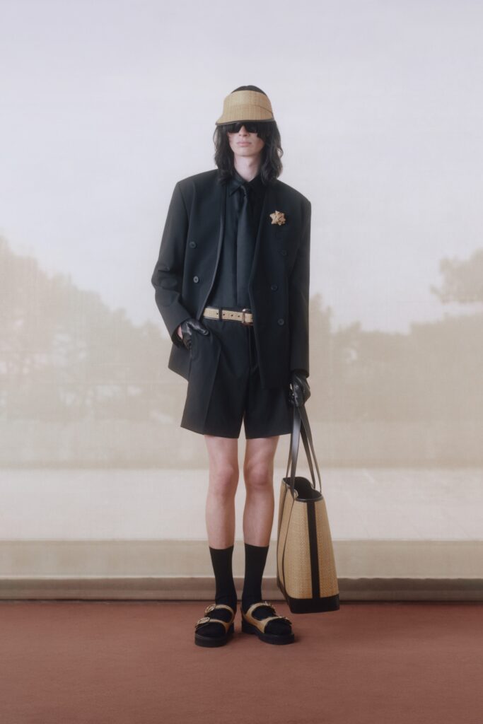 A fitted black cotton blazer paired with matching shorts, featuring a collared design and buttoned detail.