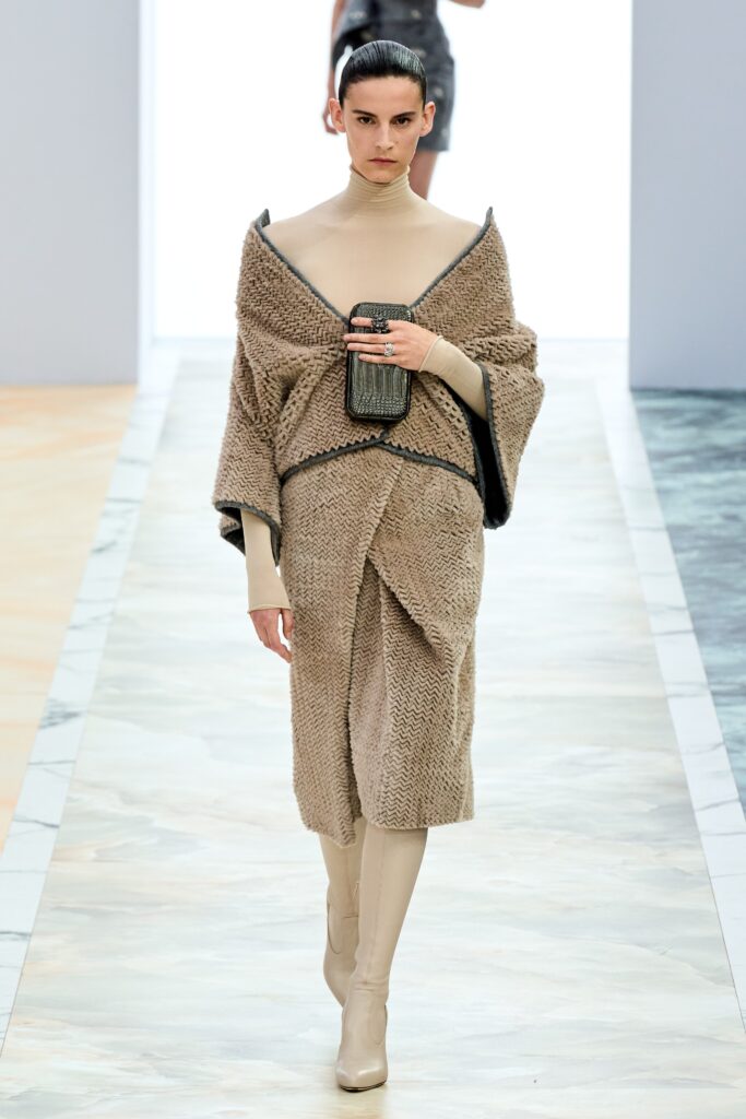A relaxed beige wool dress with long sleeves and an asymmetric design.