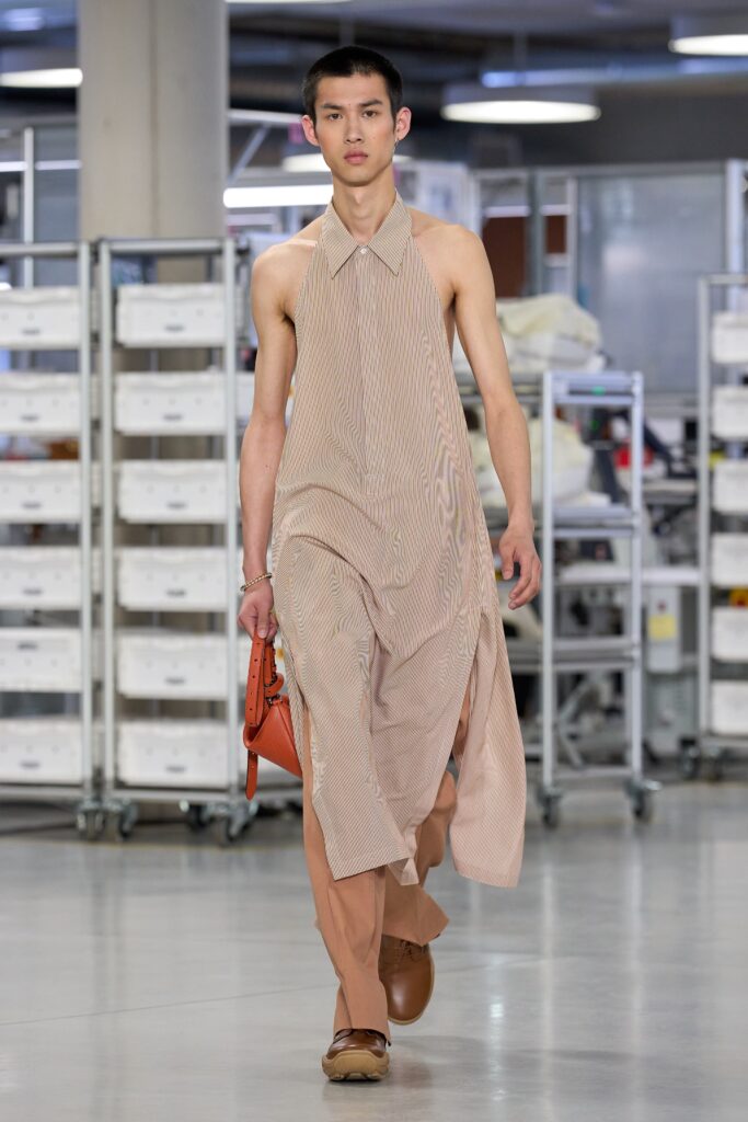 A relaxed beige cotton sleeveless dress with a collared neckline and asymmetric design.
