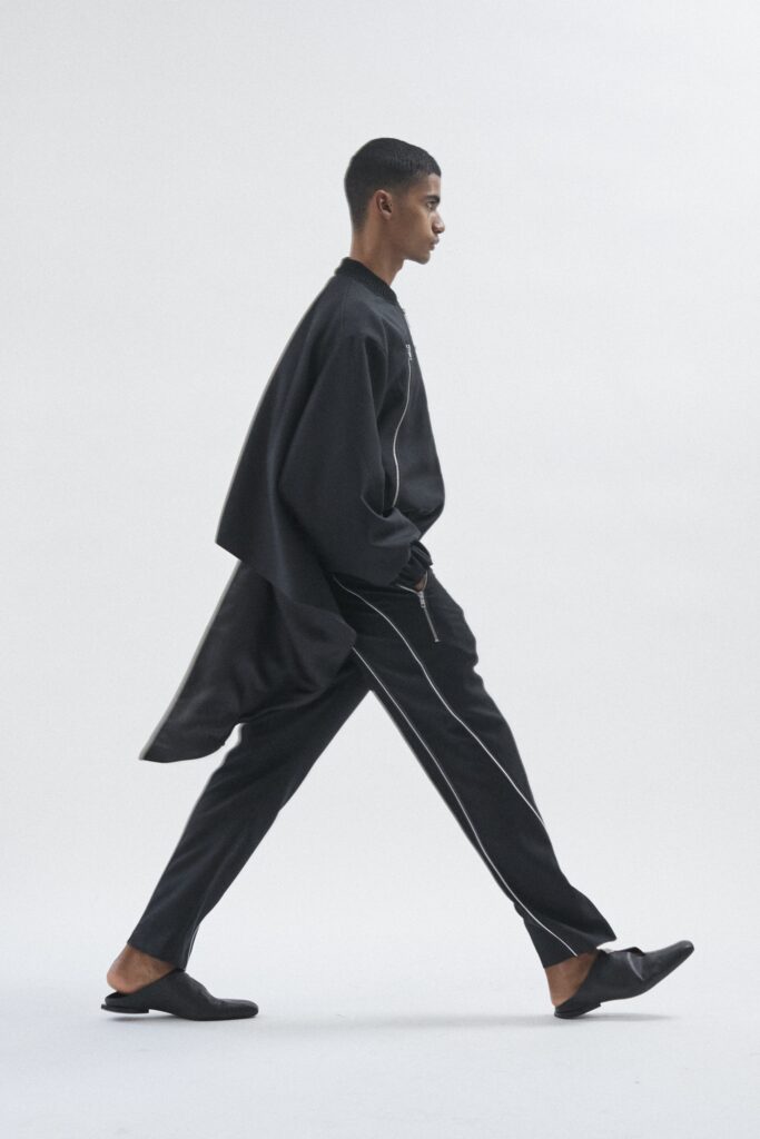 A relaxed black coat with long sleeves and a collared neckline paired with matching pants.