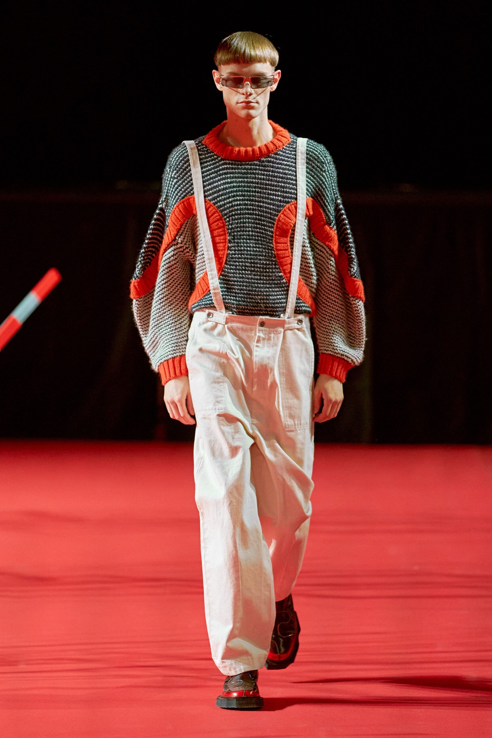 A relaxed gray printed sweater paired with loose-fitting pants, creating a contemporary streetwear look.