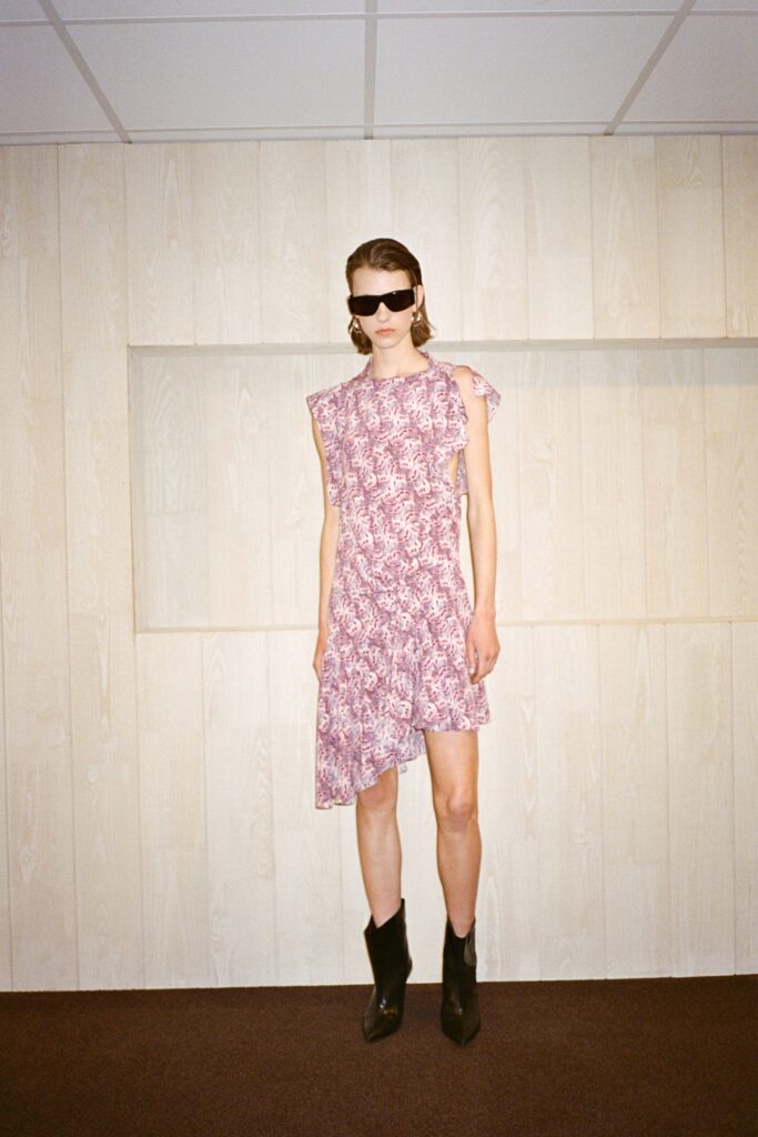 A fitted purple dress with ruffled details and an asymmetric design.