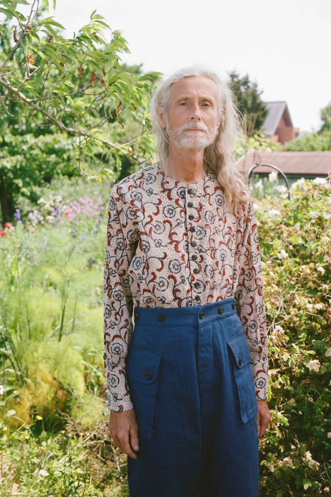A relaxed fit multicolor printed shirt paired with blue pants, featuring a long-sleeve and collared design.