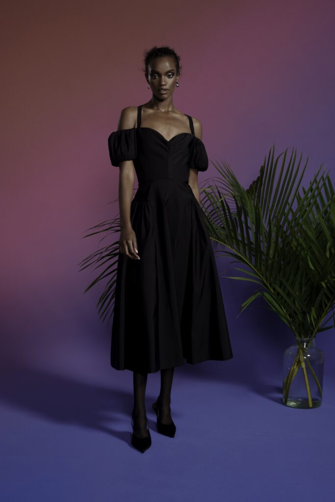 A fitted black off-shoulder dress with an A-line silhouette.