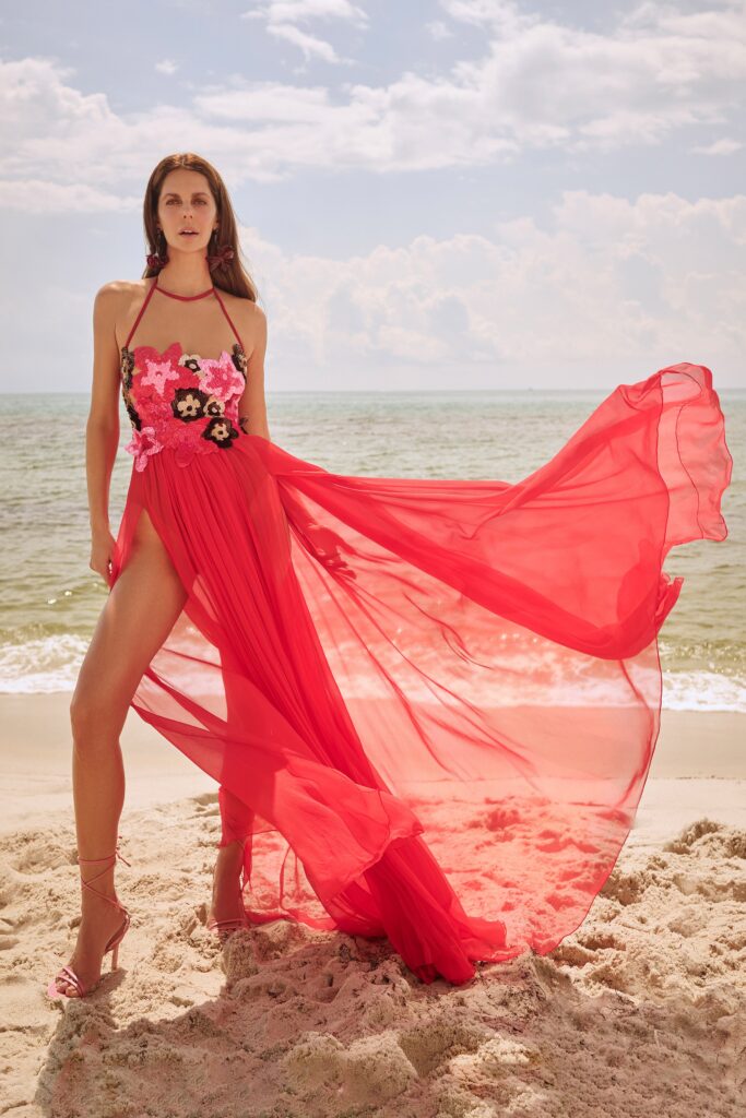 A fitted red chiffon sleeveless dress with a halter neckline and tiered design.