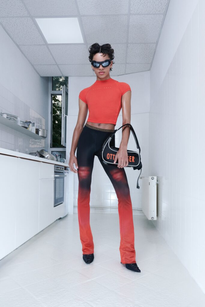 A fitted red short-sleeve top paired with high-waisted black flared pants.