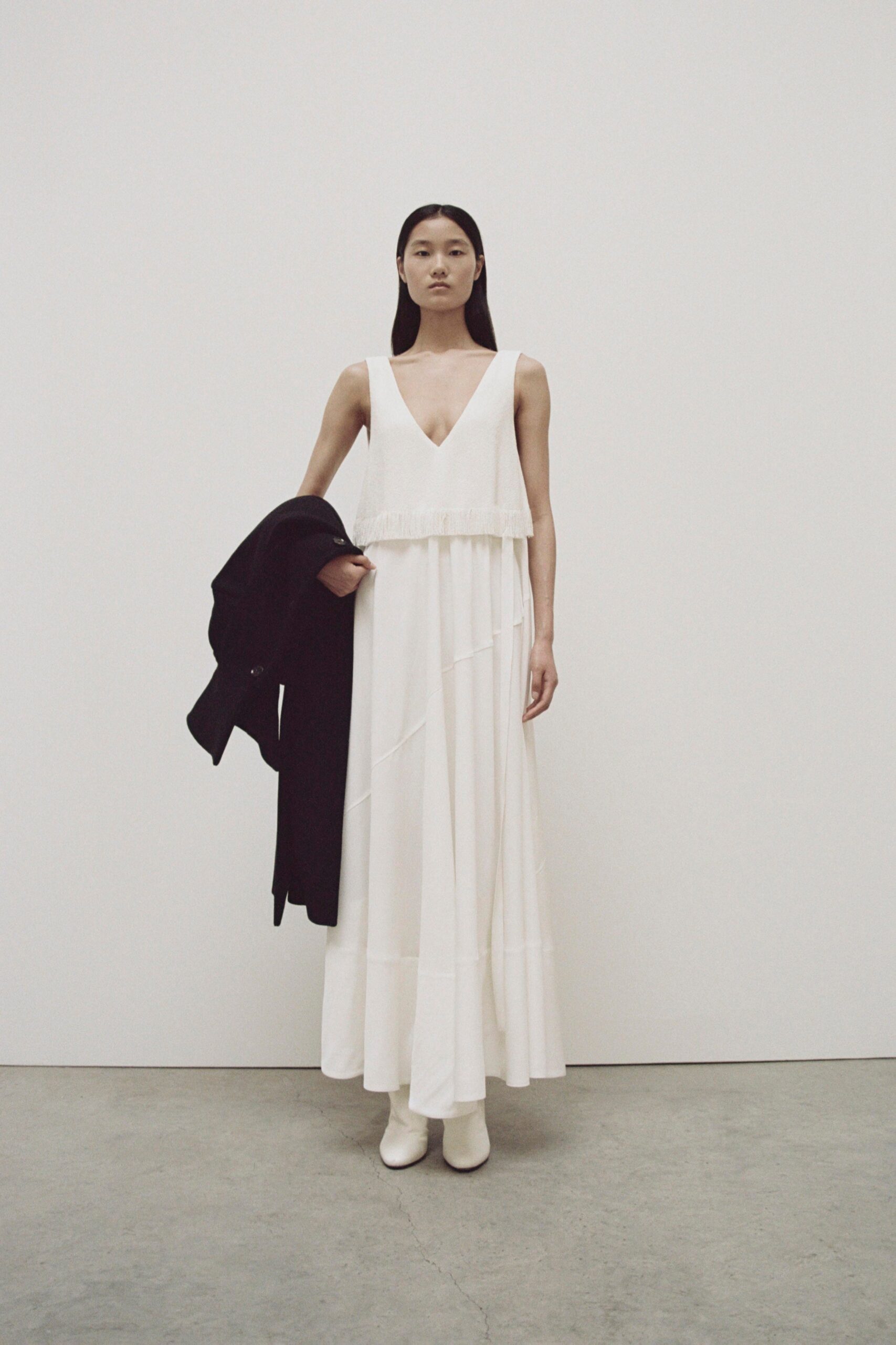 A fitted white cotton sleeveless dress with a V-neckline and maxi silhouette.