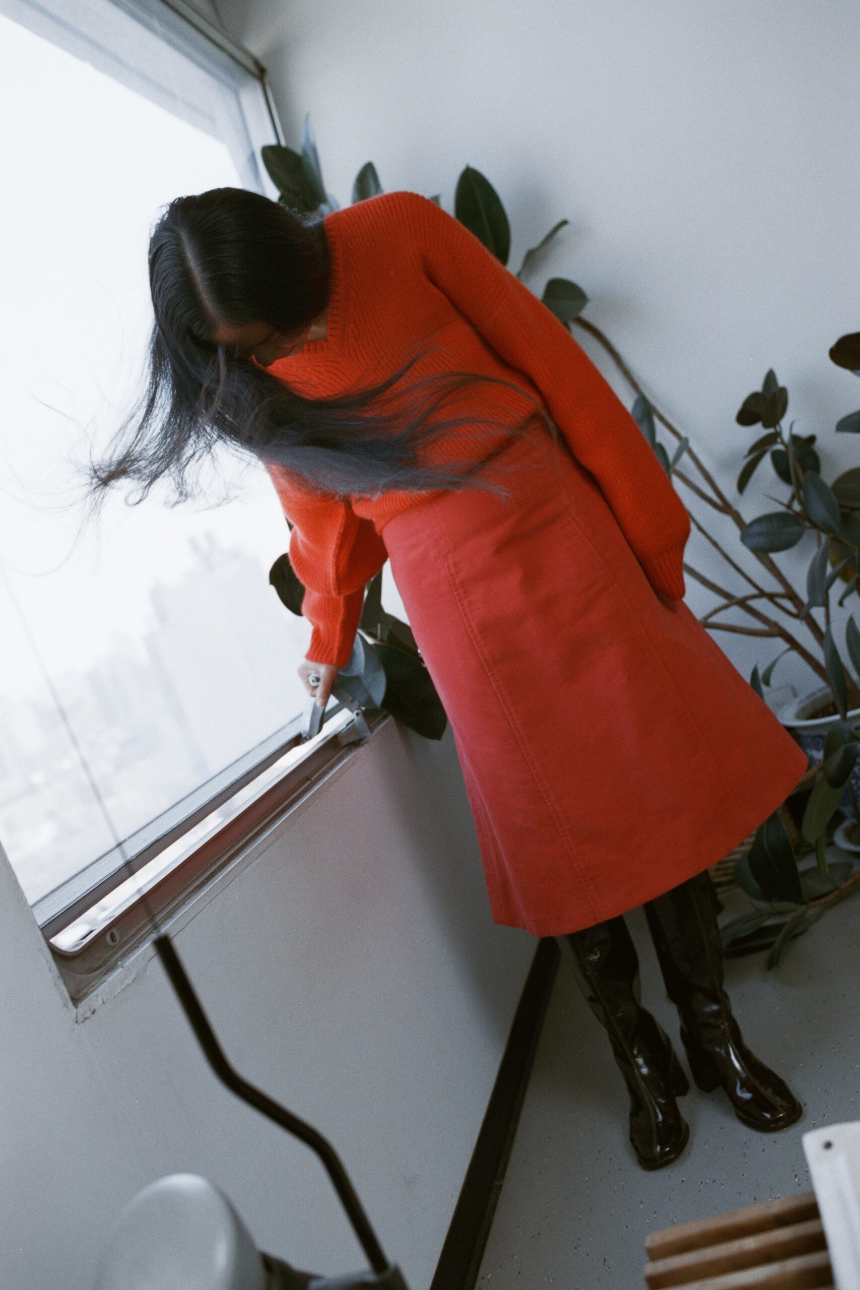 A relaxed red sweater with long sleeves paired with a straight-leg skirt.