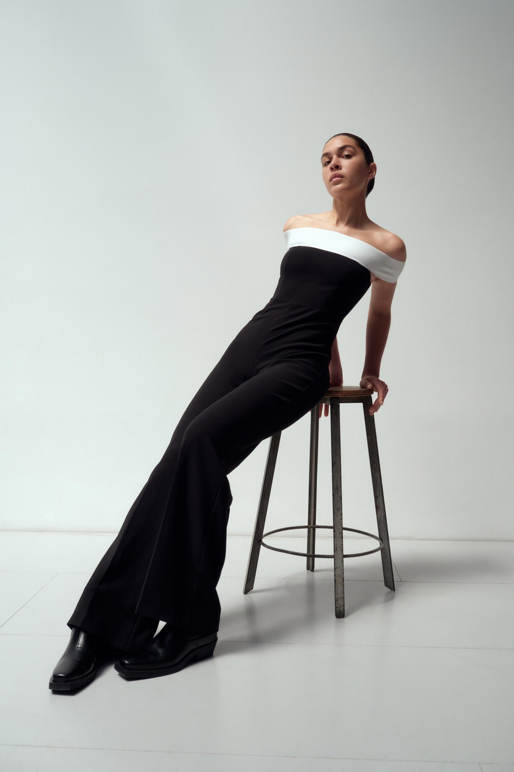A fitted black and white off-shoulder jumpsuit with flared legs.