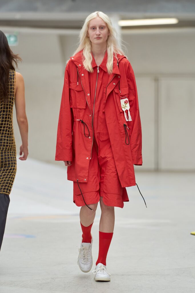 A relaxed red cotton jacket with long sleeves and a collared design paired with matching shorts.