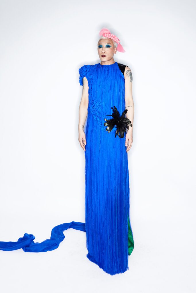 A relaxed blue silk sleeveless dress with a high neckline and asymmetric design.