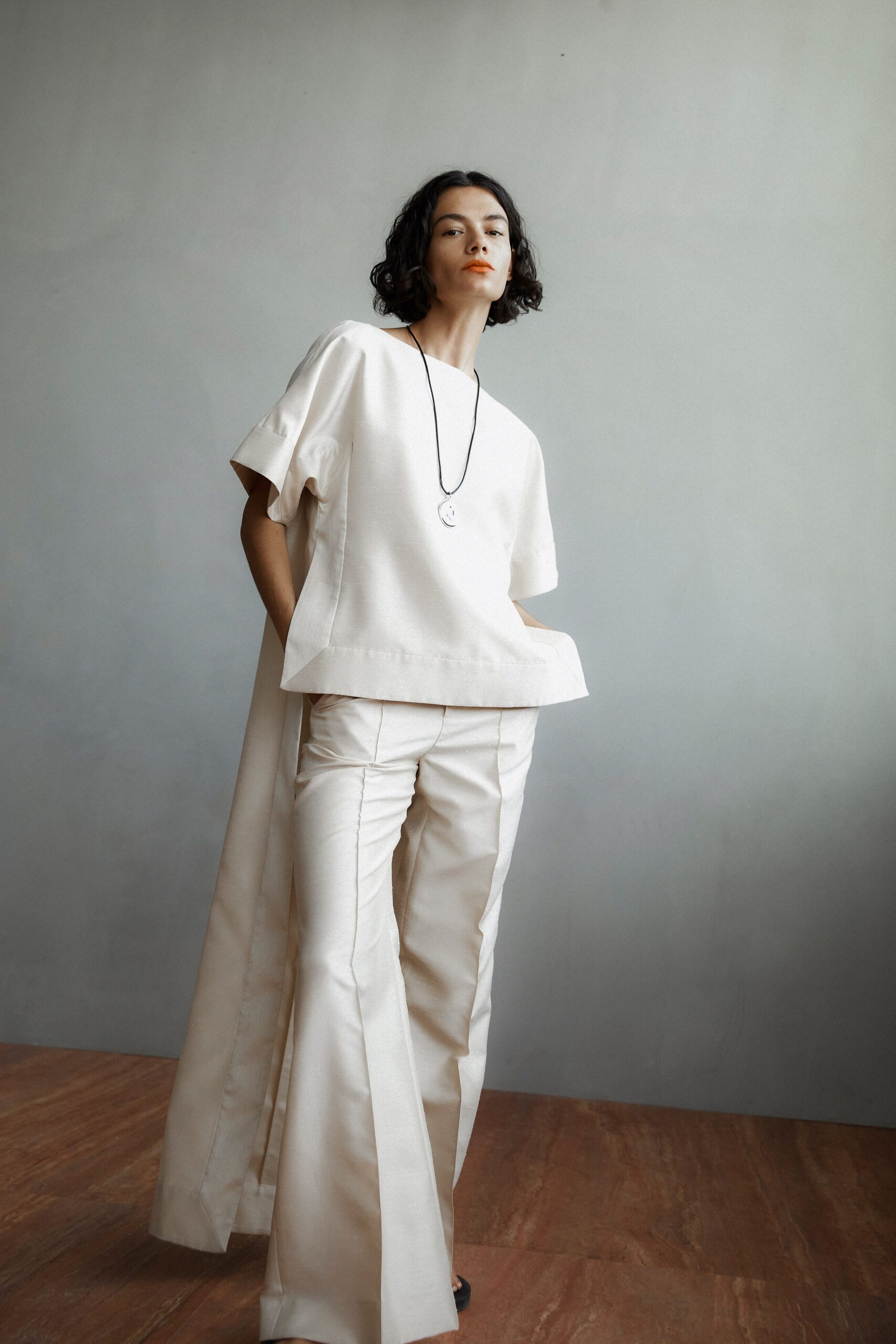 A relaxed beige top with short sleeves paired with wide-leg pants.