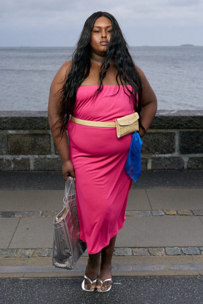 A fitted pink strapless dress with an asymmetric silhouette, perfect for a stylish summer look.