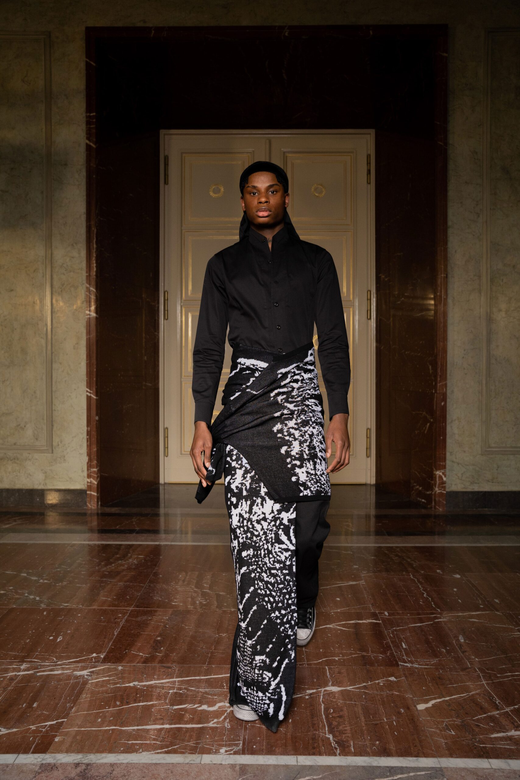 A fitted black long-sleeve shirt paired with an asymmetric printed skirt.