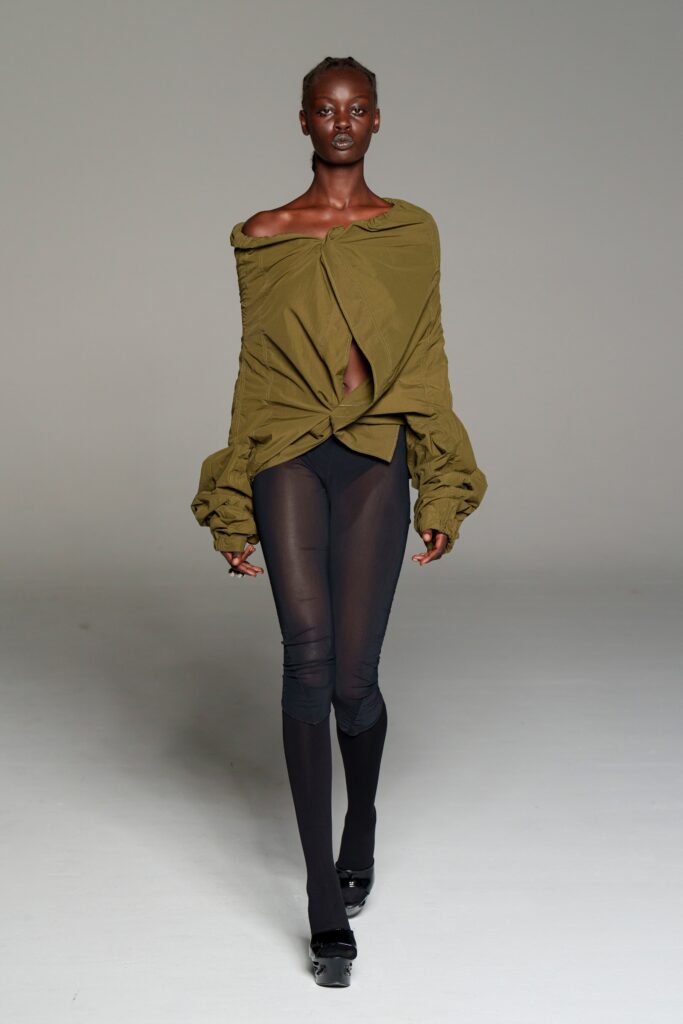 green off-shoulder top with black leggings