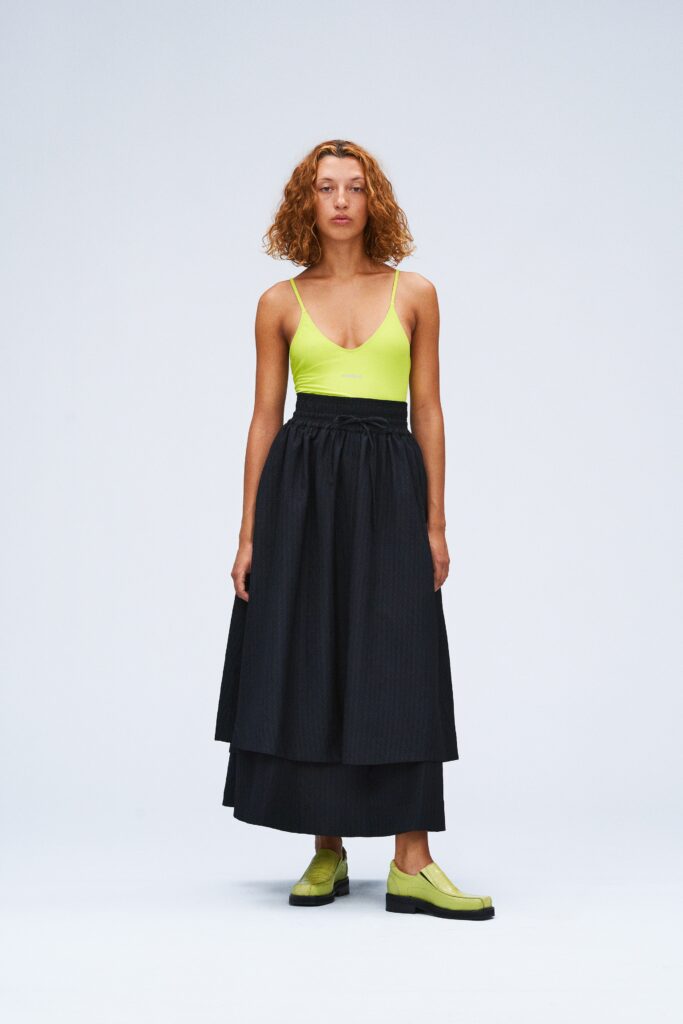 green fitted top with black skirt