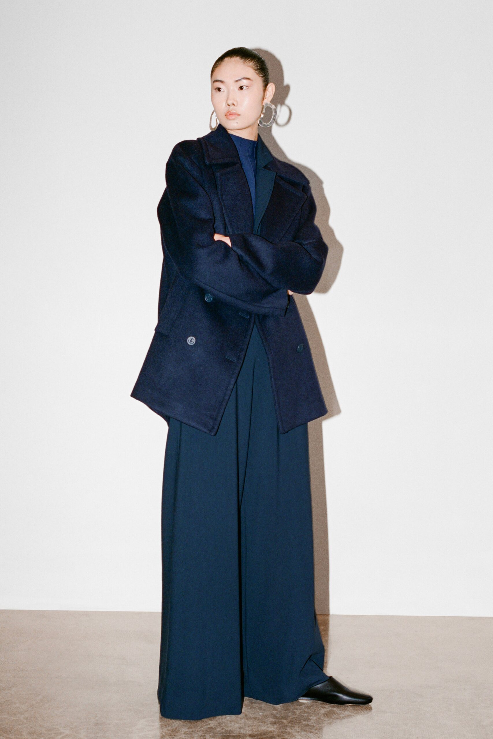 A relaxed blue wool jacket paired with wide-leg pants, featuring a long-sleeve and collared design.