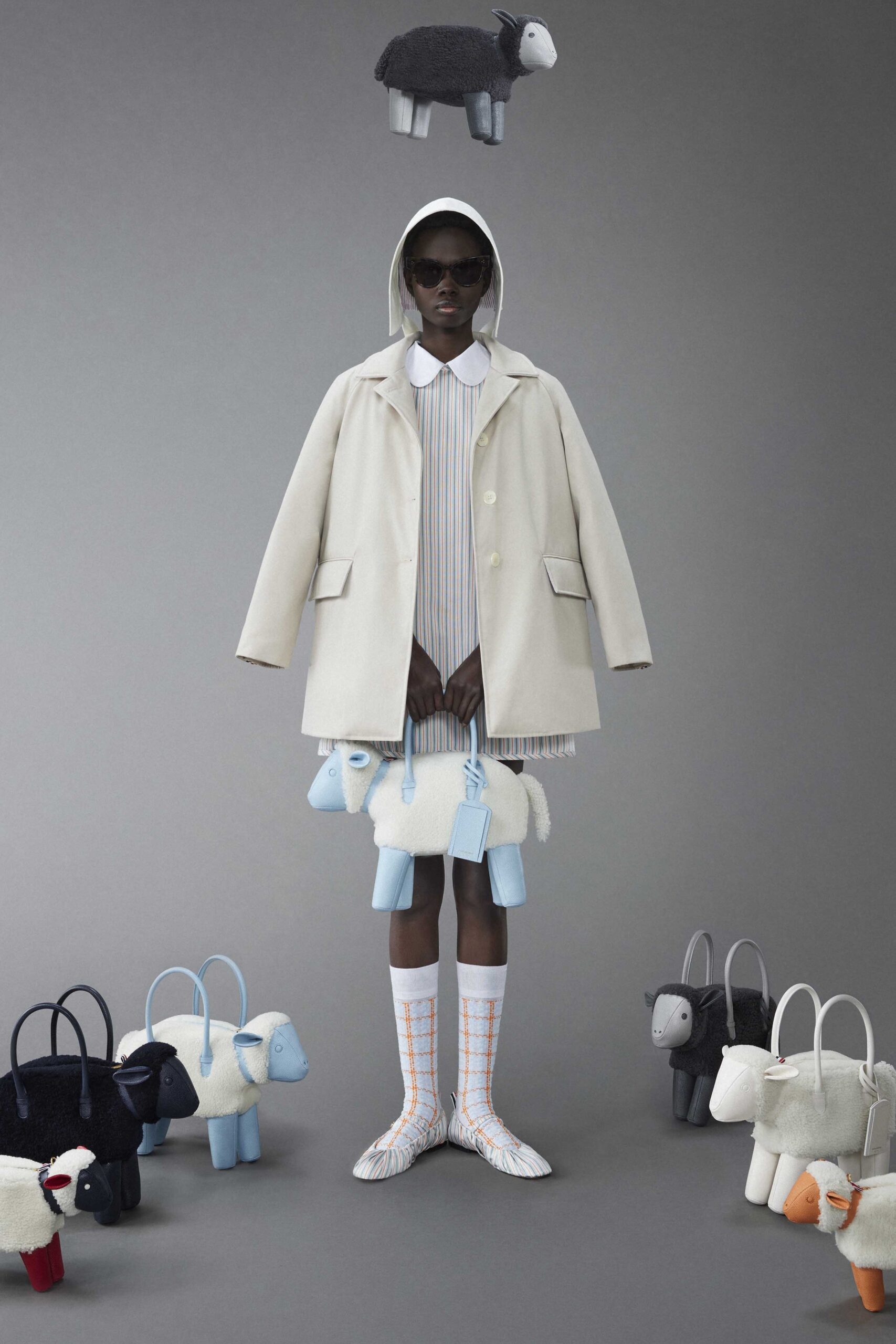 A relaxed white coat layered over a striped dress with long sleeves and a collared neckline.