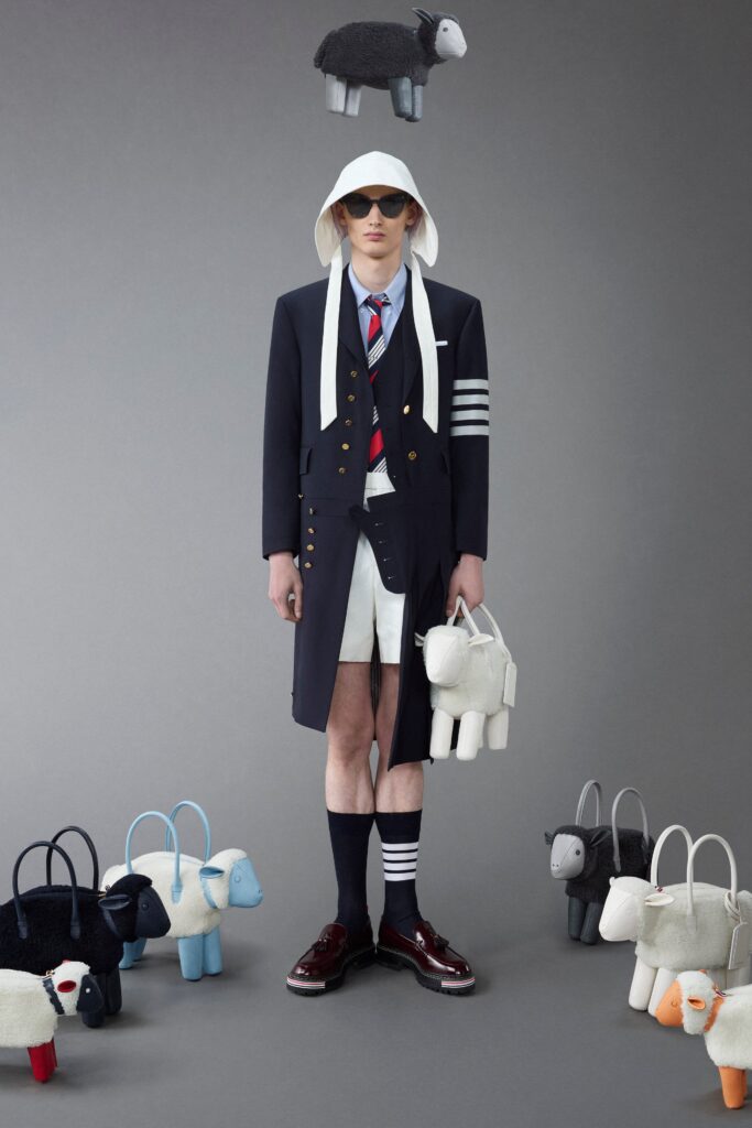 A fitted black and white coat with a collared design, paired with high-waisted shorts.
