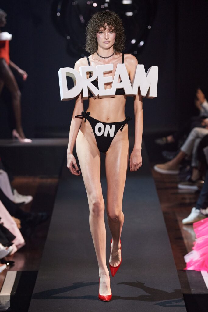 A fitted black bikini with a low-cut design featuring a printed message.