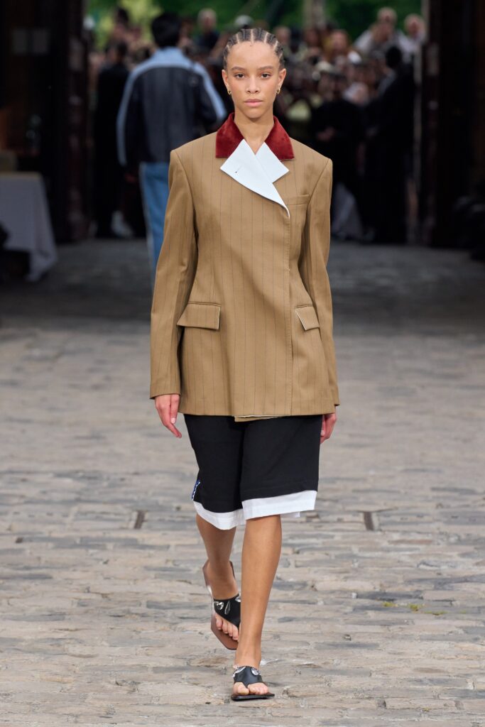 A relaxed brown striped jacket paired with black and white shorts, featuring a collared neckline.