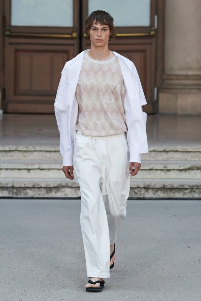 A relaxed white long-sleeve collared shirt paired with printed pants.